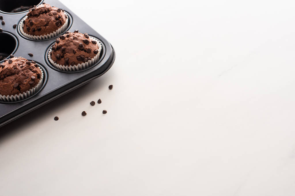свежие шоколадные кексы в олове из кексов на белой поверхности
 - Фото, изображение