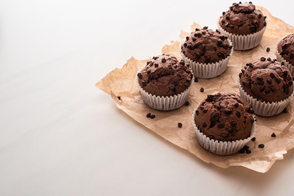 muffins de chocolate fresco en papel pergamino
 - Foto, imagen