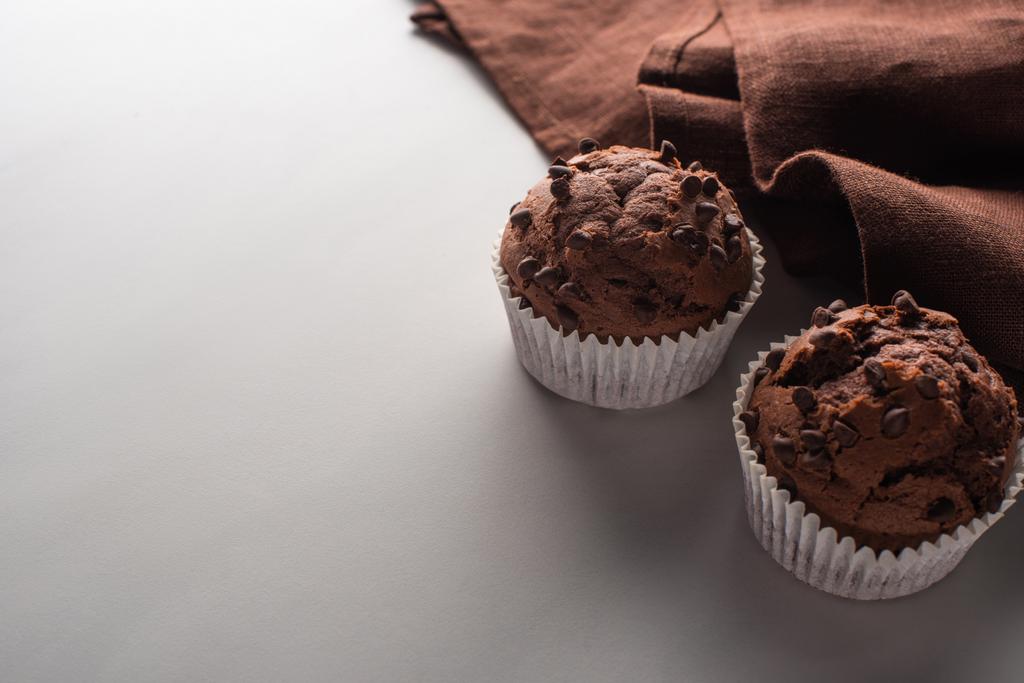 fresh chocolate muffins with brown napkin on marble surface - 写真・画像