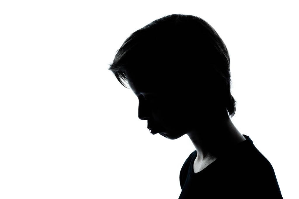 een Kaukasische jonge tiener silhouet jongen of meisje portret humeurig steenbolk triest in studio uitgesneden geïsoleerd op witte achtergrond - Foto, afbeelding
