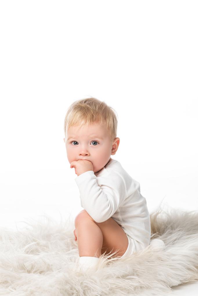 Cute boy putting hand in mouth, looking at camera isolated on white  - Photo, Image