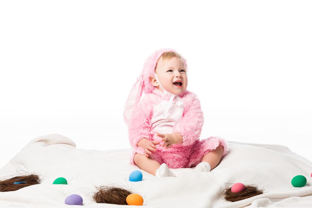 Criança vestindo traje de coelho, gritando em cobertor com decoração colorida isolada no branco
  - Foto, Imagem