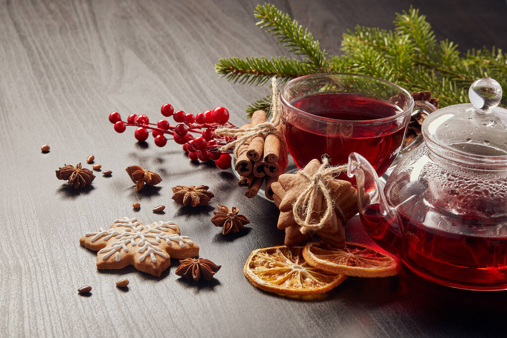 Galletas de jengibre, té de frutas y ramas de abeto sobre un fondo negro de madera. Navidad y Año Nuevo. - Foto, Imagen