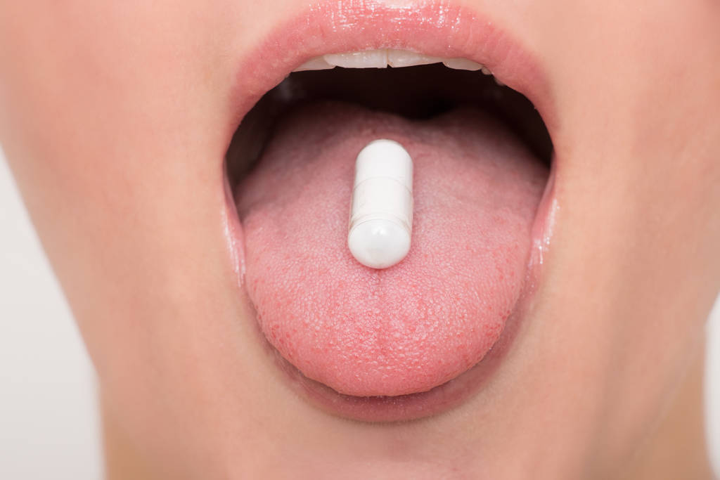 Tabletka powlekana między zębami kobiety - Zdjęcie, obraz