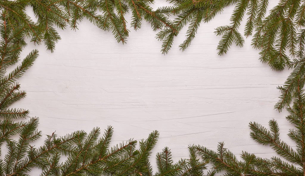 White wooden background with frame from fir branches. New Year and Christmas - Photo, Image