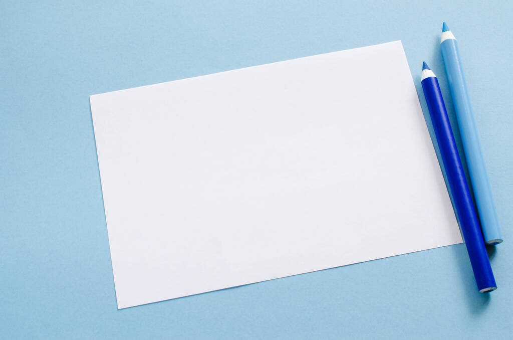 Белый чистый лист бумаги и два голубых карандаша. Макет копировального пространства. Взгляд сверху, Образование
. - Фото, изображение