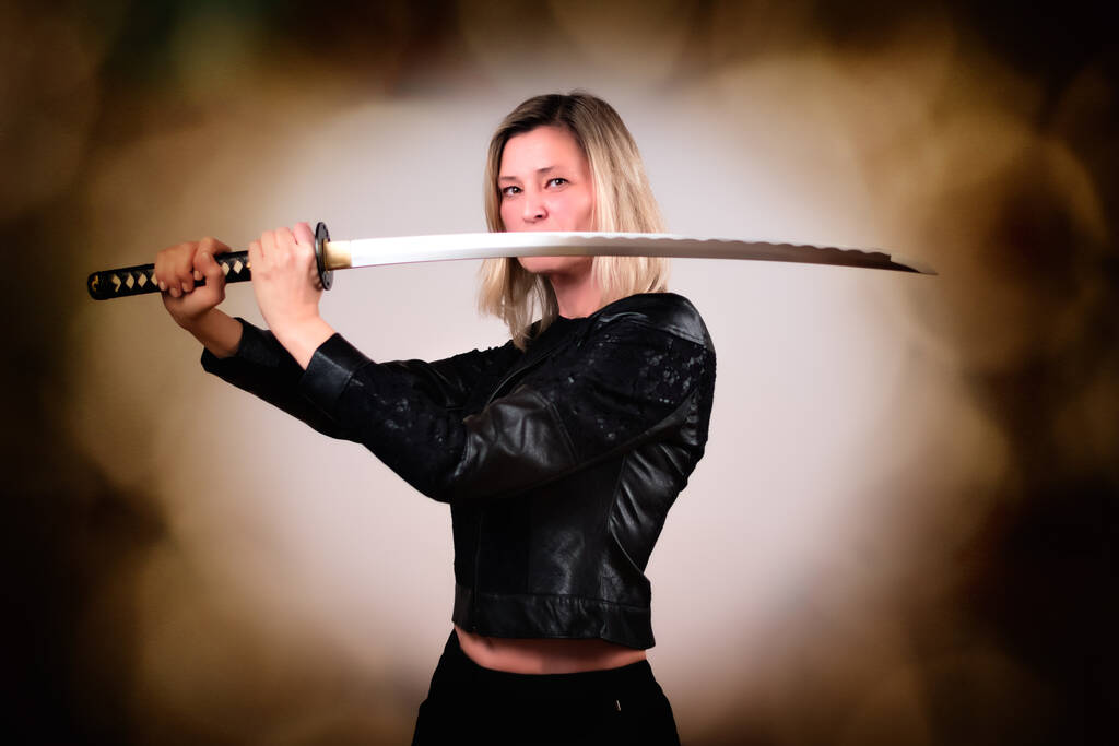 Strong female fighter with samurai sword in action - Photo, Image