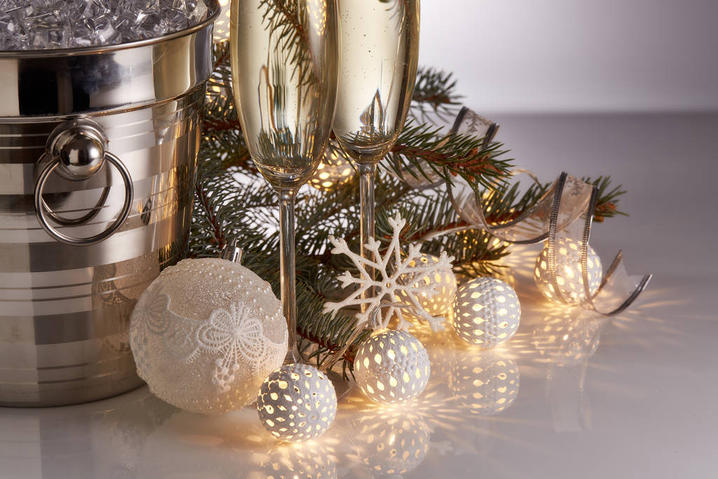 Buzlu bir kovada duran şampanya şişesi, iki dolu şampanya kadehi, öncü ışık çelengi ve Noel süsleriyle dolu bir hayat. Noel ve Yeni Yıl kutlamaları - Fotoğraf, Görsel
