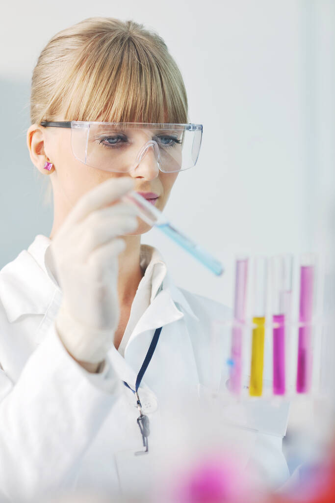 Студентка-доктор женщина-исследователь держит пробирку по химии яркой лаборатории
 - Фото, изображение