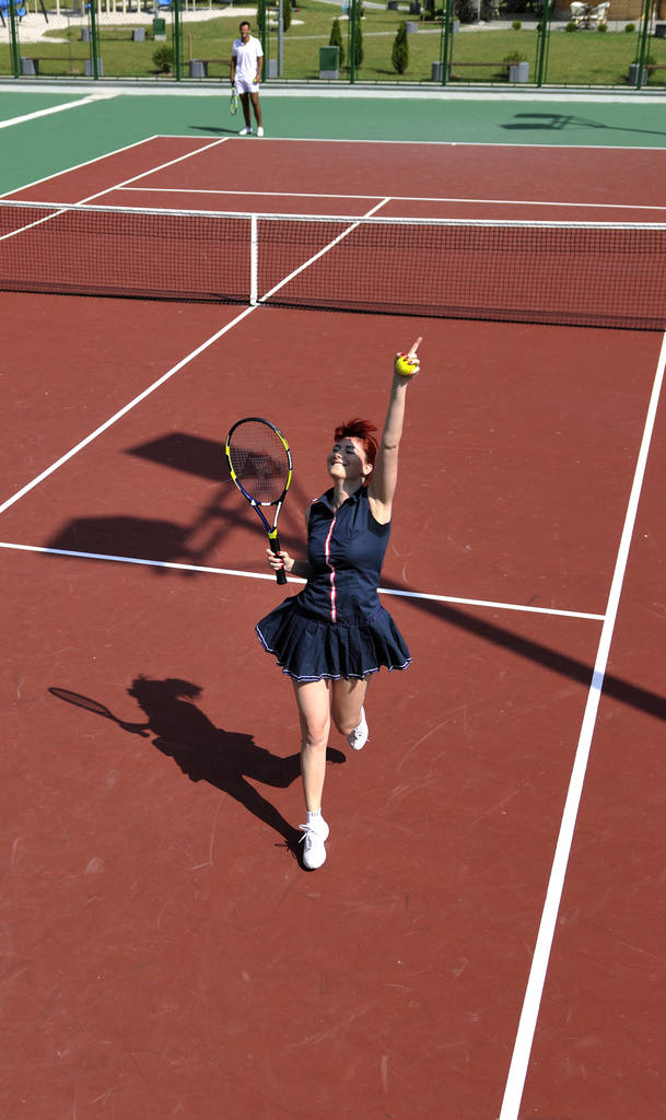 若い女性テニス オレンジ テニス フィールドに屋外早朝にフィットします。 - 写真・画像