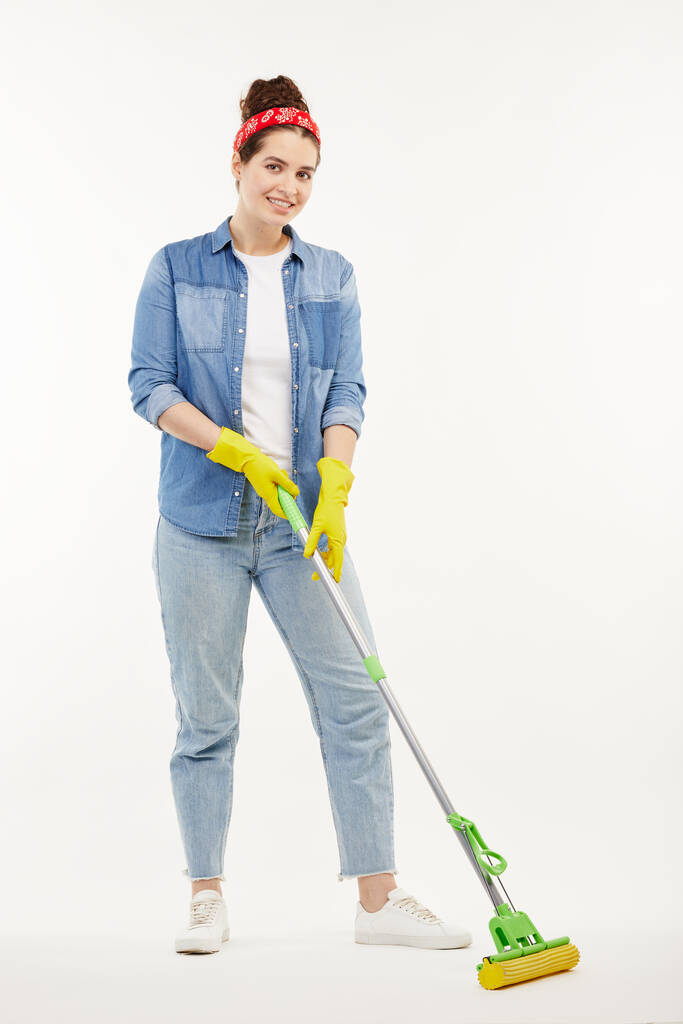 Pretty woman in work-wear holds a green mop. - Photo, Image