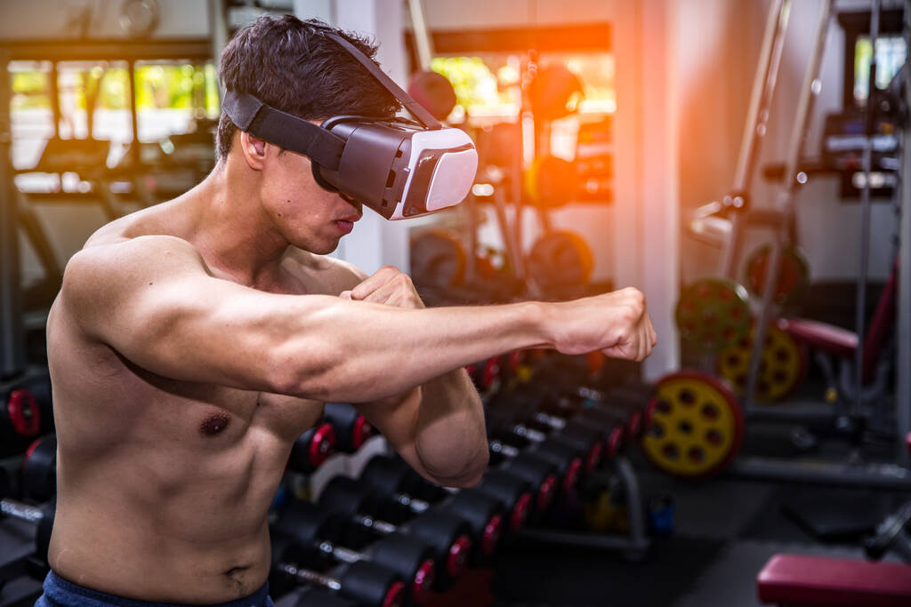 Jeune boxeur fit en lunettes vr formation dans le jeu de boxe en réalité virtuelle, jeu futuriste
. - Photo, image
