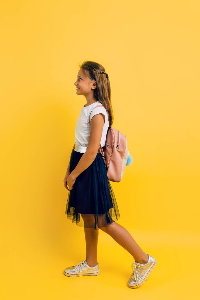 Retrato de una colegiala sonriente con una mochila en un yel
 - Foto, Imagen