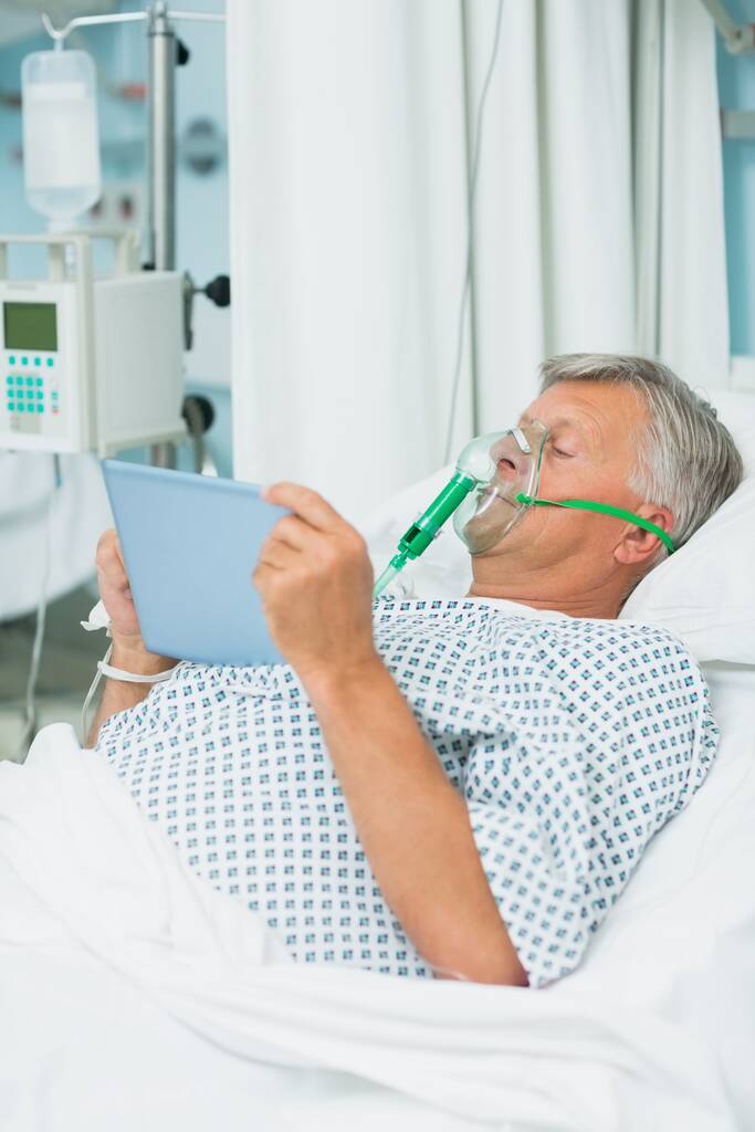 Patient homme portant un masque à oxygène dans un lit d'hôpital - Photo, image