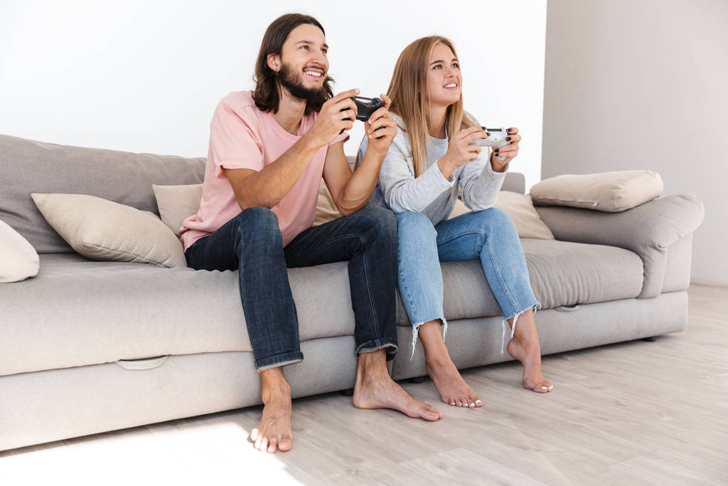 感情的な若い愛するカップルがビデオゲームをプレイ - 写真・画像