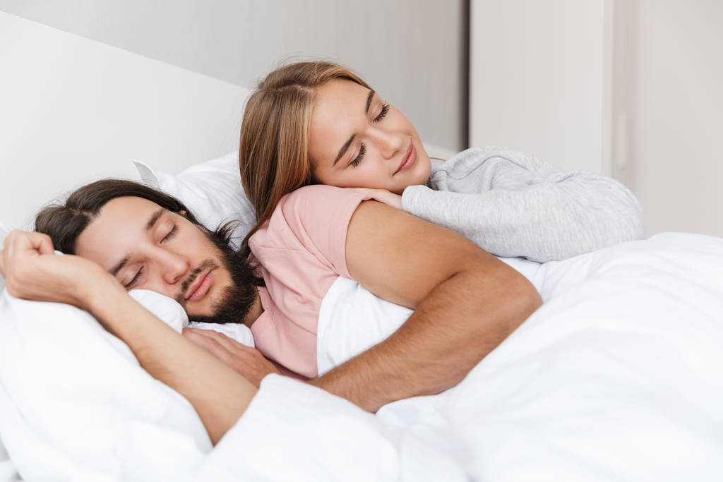 Красивая молодая пара, лежащая в постели
 - Фото, изображение