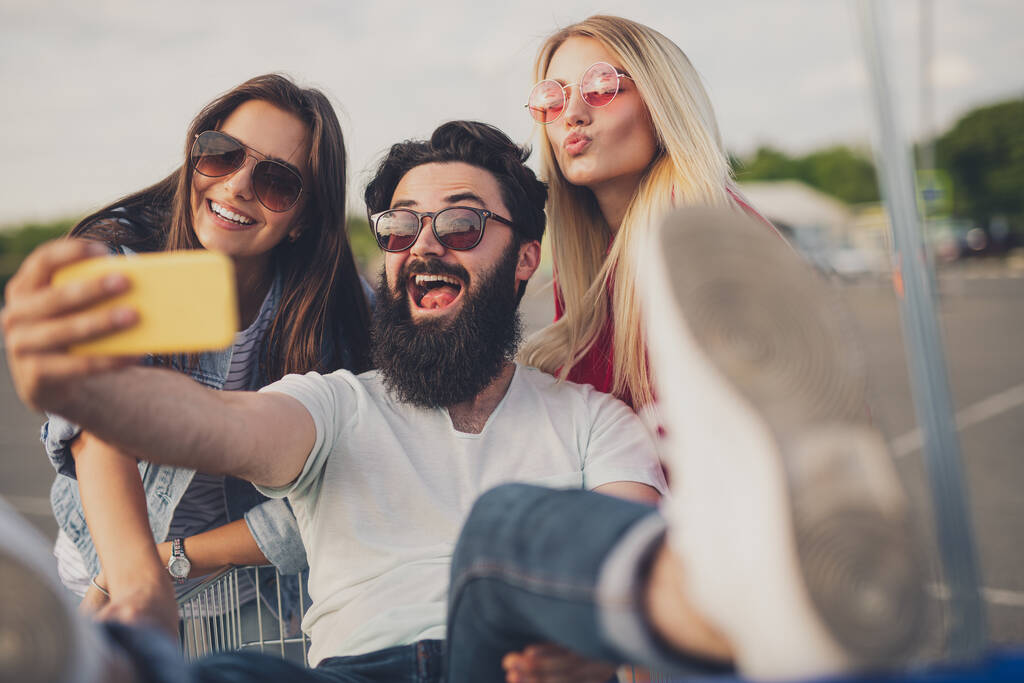 baard man nemen selfie met vrouwen tijdens het winkelen - Foto, afbeelding