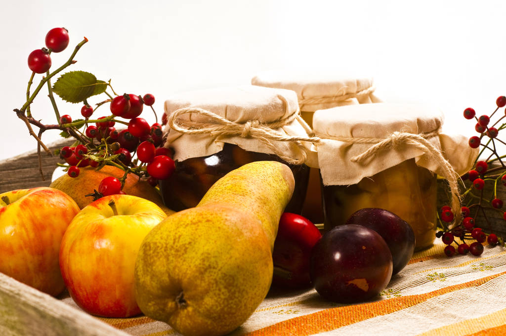 вареные фрукты в кувшинах и свежие на деревянном подносе - Фото, изображение