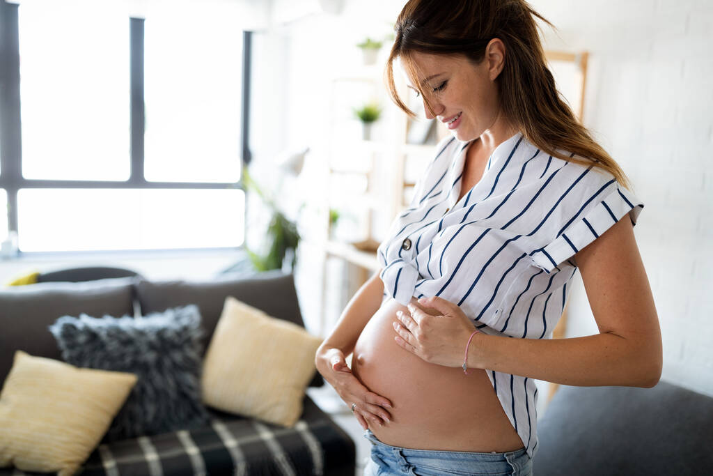 Gyönyörű terhes nő várandós, és vigyáz a bőr és a terhességi csíkok - Fotó, kép