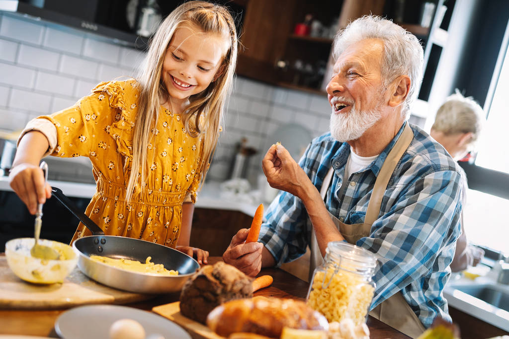 Sonriendo feliz abuelo ayudar a los niños a cocinar en la cocina - Foto, Imagen