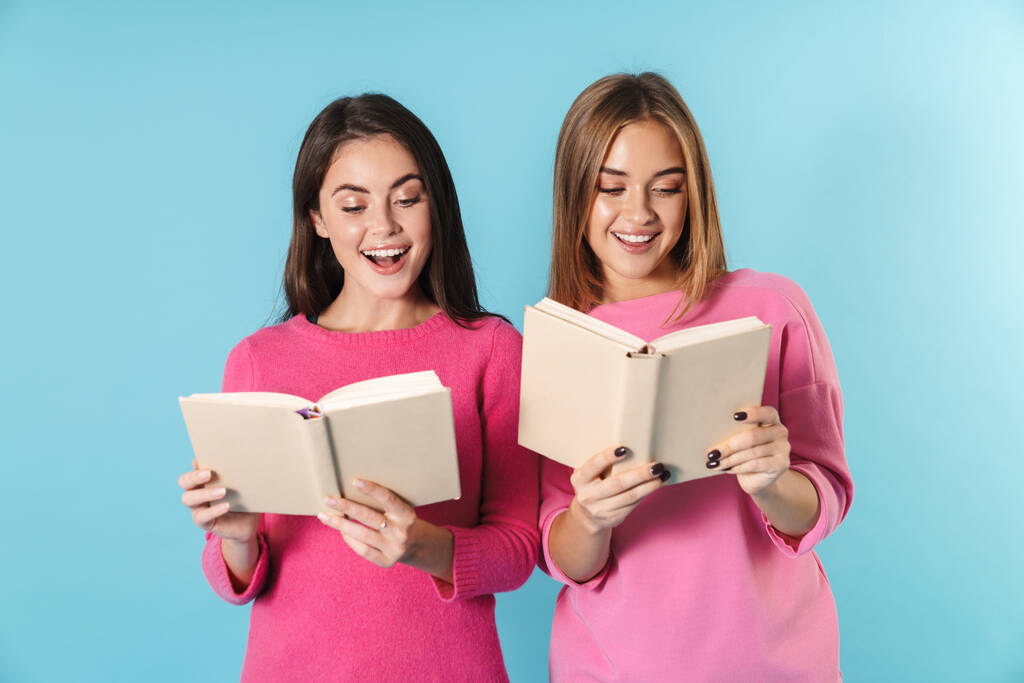 Foto de mujeres jóvenes y alegres sonriendo y leyendo libros
 - Foto, Imagen