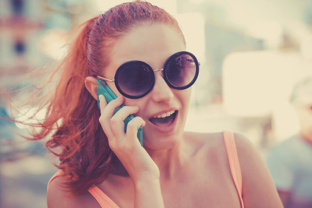 Zaskoczona dziewczyna rozmawiająca przez telefon komórkowy z otwartymi ustami, ruda głowa - Zdjęcie, obraz
