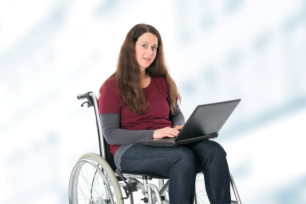 mujer joven en silla de ruedas trabajando con el ordenador
 - Foto, Imagen
