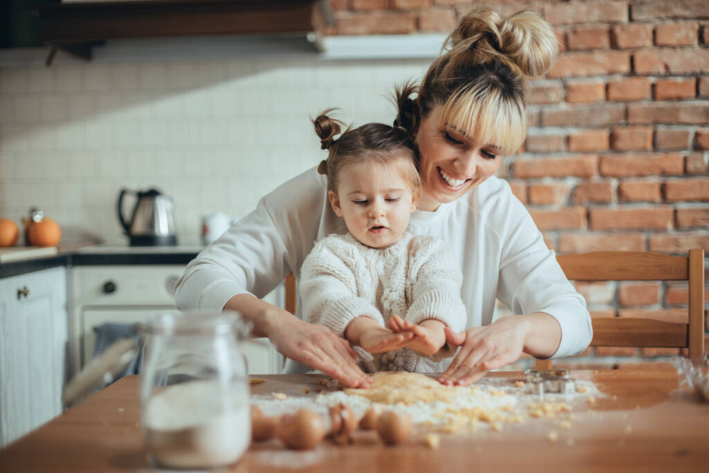 Äiti ja tytär leipoo evästeitä keittiössään
 - Valokuva, kuva