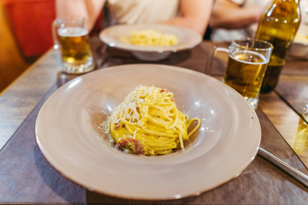 Πάστα καρμπονάρα. Ένας άντρας τρώει ένα ιταλικό πιάτο μακαρόνια καρμπονάρα. - Φωτογραφία, εικόνα