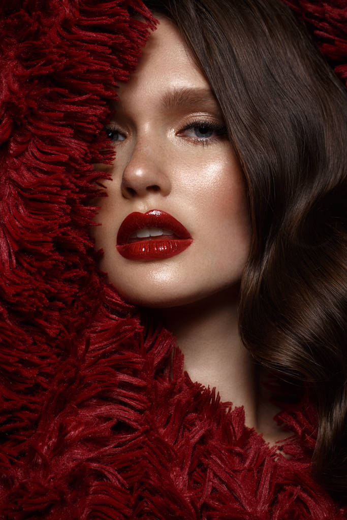A beautiful girl with evening make-up, a curls wave and red lips. Beauty face. - Photo, Image