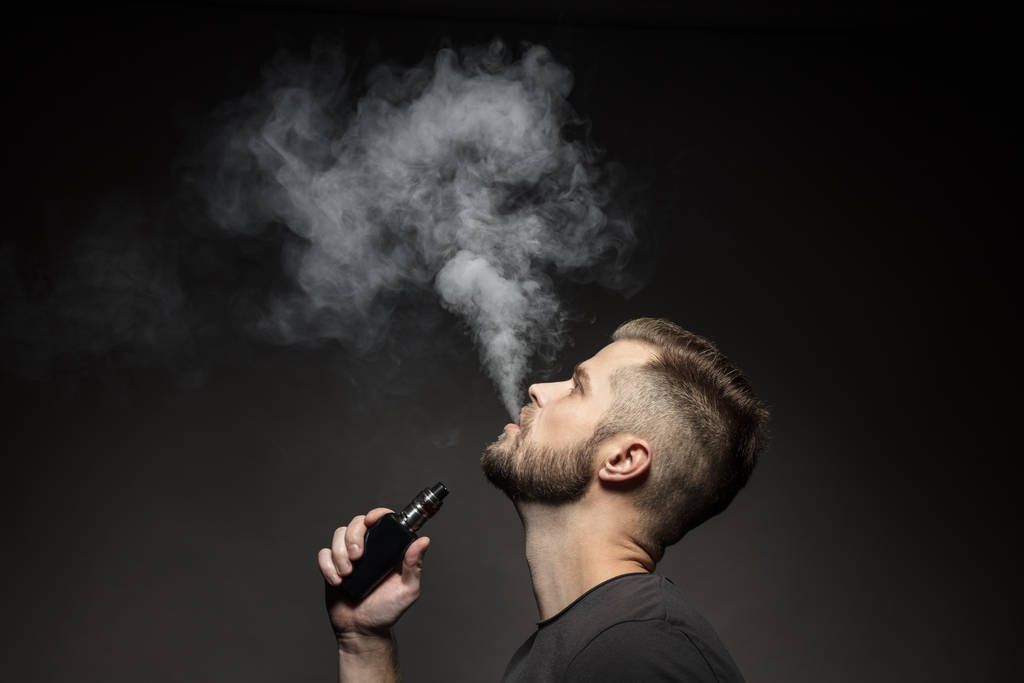 Vaping e-liquid from an electronic cigarette - Photo, Image