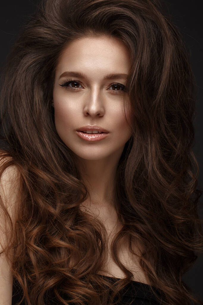 Mooie brunette model: volume krullen, klassieke make-up en sexy lippen. Het gezicht van de schoonheid. - Foto, afbeelding