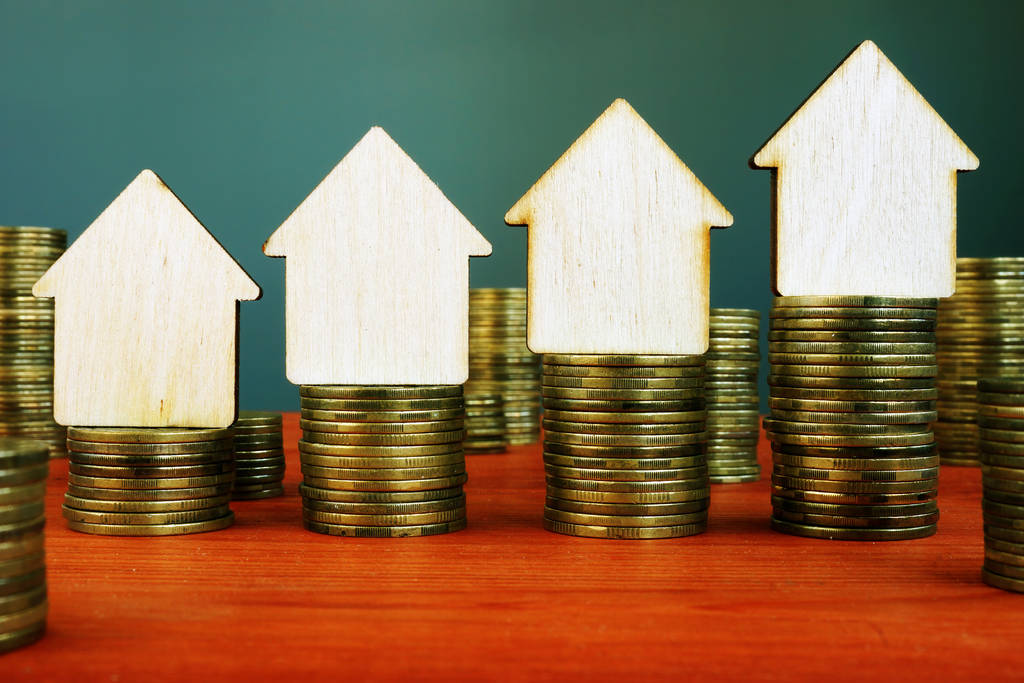 Immobilieninvestitionskonzept. Stapel von Münzen und kleine Häuser. - Foto, Bild