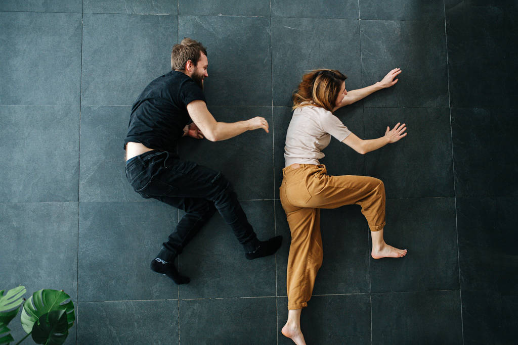 Para bawiąca się w pościg, biegająca leżąc na podłodze - Zdjęcie, obraz