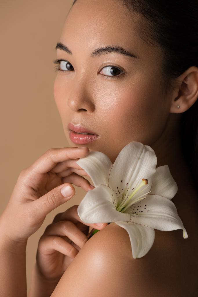 beautiful naked asian girl holding white lily isolated on beige - Photo, Image