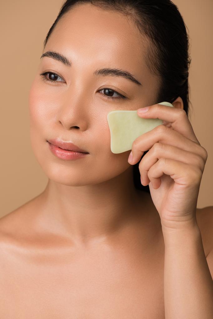 belle nu asiatique fille à l'aide faciale gua sha jade conseil isolé sur beige
 - Photo, image