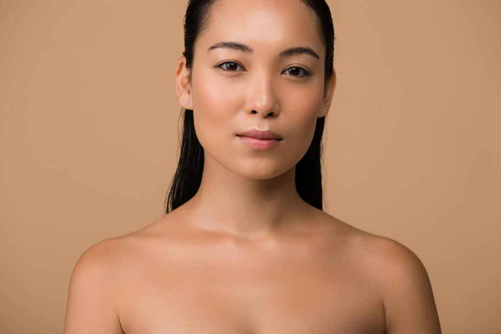 hermosa desnuda chica asiática mirando a la cámara aislada en beige
 - Foto, imagen