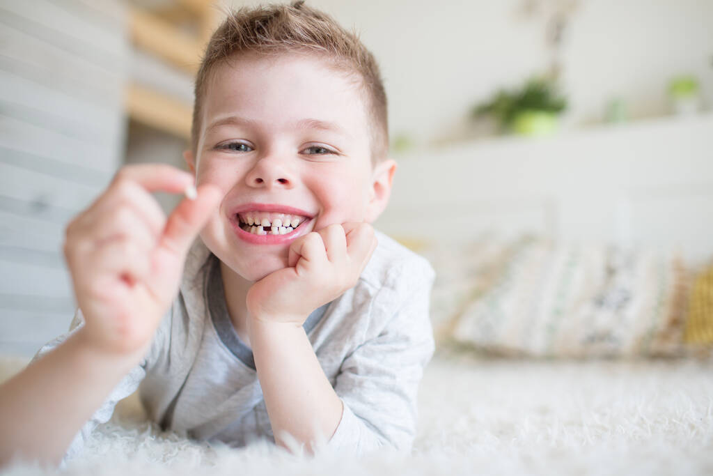 Criança adolescente com um dente retirado
 - Foto, Imagem