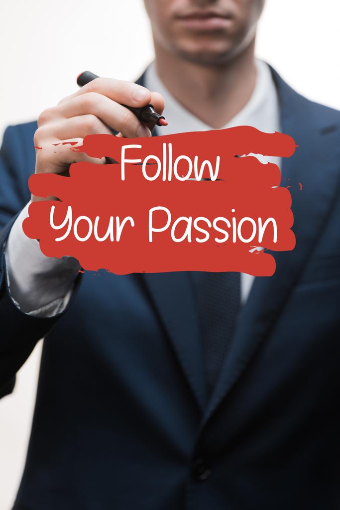selective focus of businessman in formal wear holding marker pen near follow your passion lettering on white  - Photo, Image