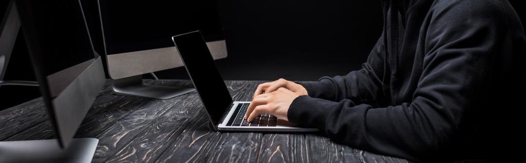 ブラックに隔離されたノートパソコンのキーボードに入力したハッカーのパノラマ写真  - 写真・画像