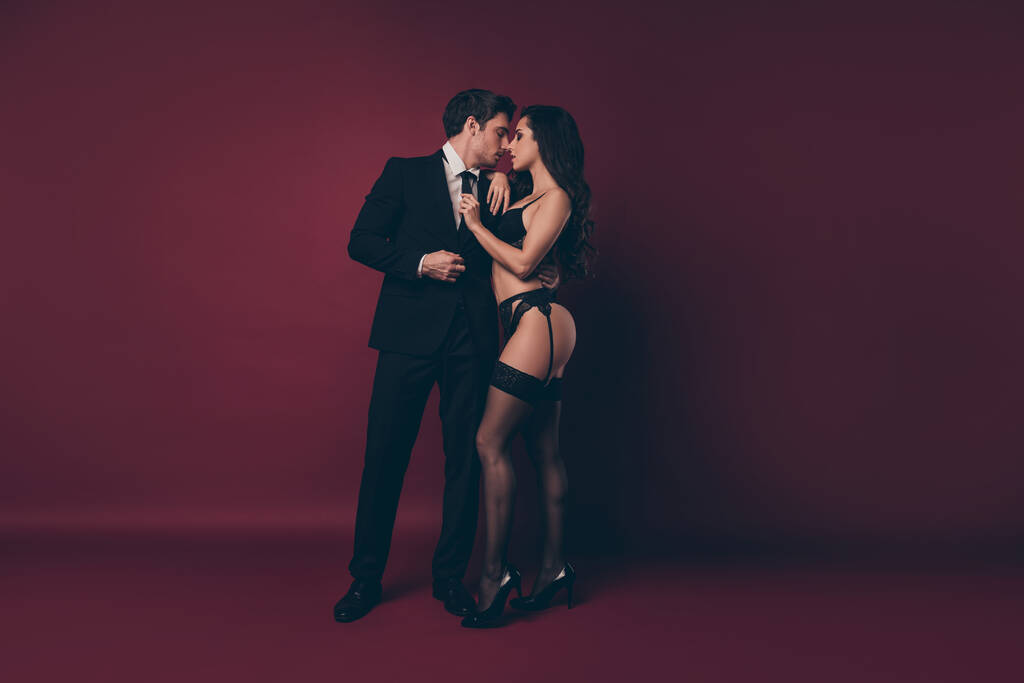 Full size photo of horny couple two people husband return home work nude hot shapes black underwear wife meets macho undress his office suit isolated burgundy color background - 写真・画像