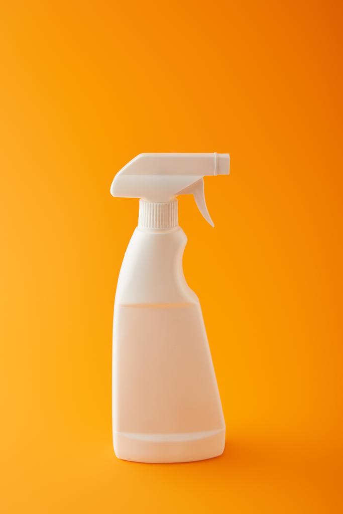 eine weiße Sprühflasche auf Orange, Reinigungsprodukt - Foto, Bild