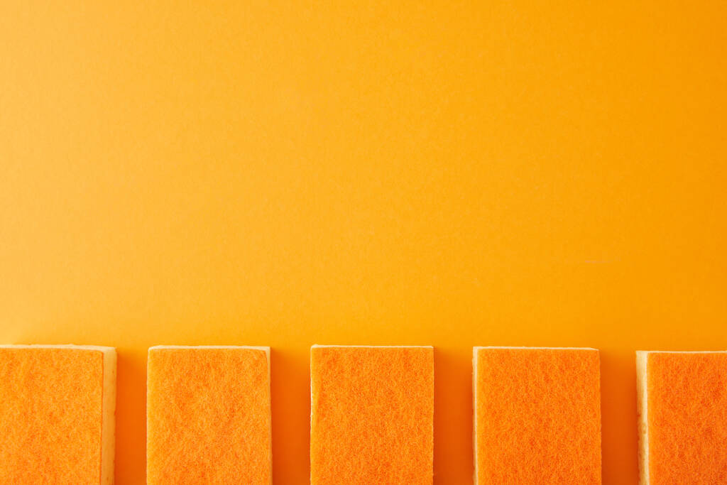 tendido plano con fila de esponjas para la limpieza de la casa en naranja
 - Foto, Imagen