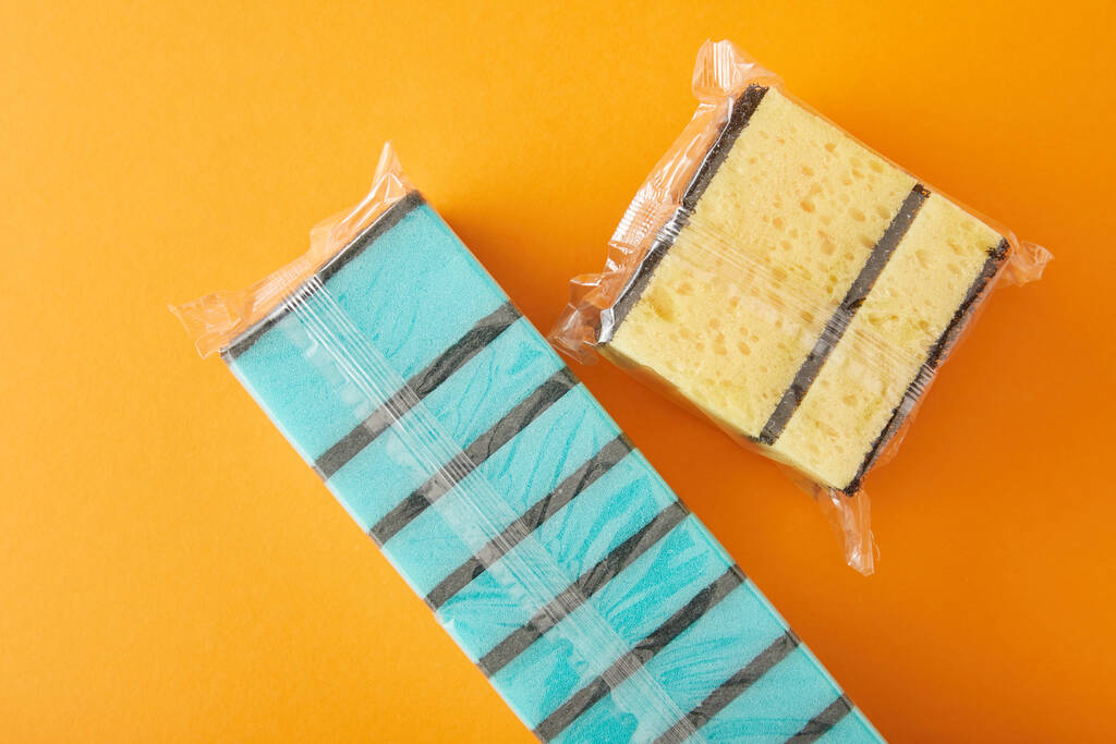 top view of packed blue and yellow sponges for house cleaning on orange - Photo, Image