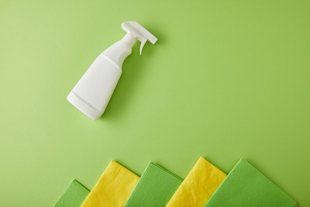 vista superior de trapos e frasco de spray para limpeza da casa em verde
 - Foto, Imagem