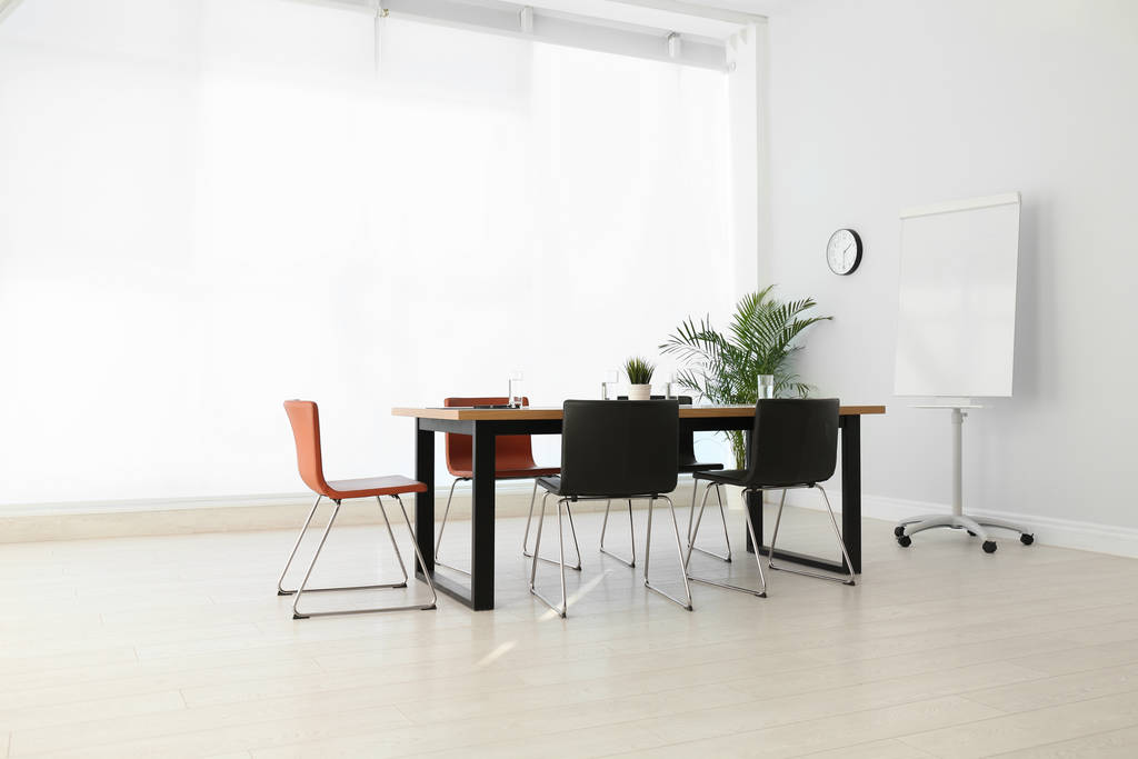 Jednoduchý kancelářský interiér s velkým stolem a židlemi - Fotografie, Obrázek