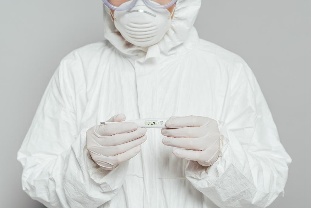 zugeschnittene Ansicht eines Epidemiologen mit Thermometer, das hohe Temperatur isoliert auf grau zeigt - Foto, Bild