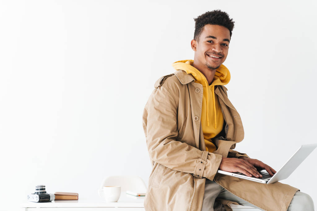 Foto von glücklichen afrikanisch-amerikanischen Mann mit Laptop und lächelnd - Foto, Bild