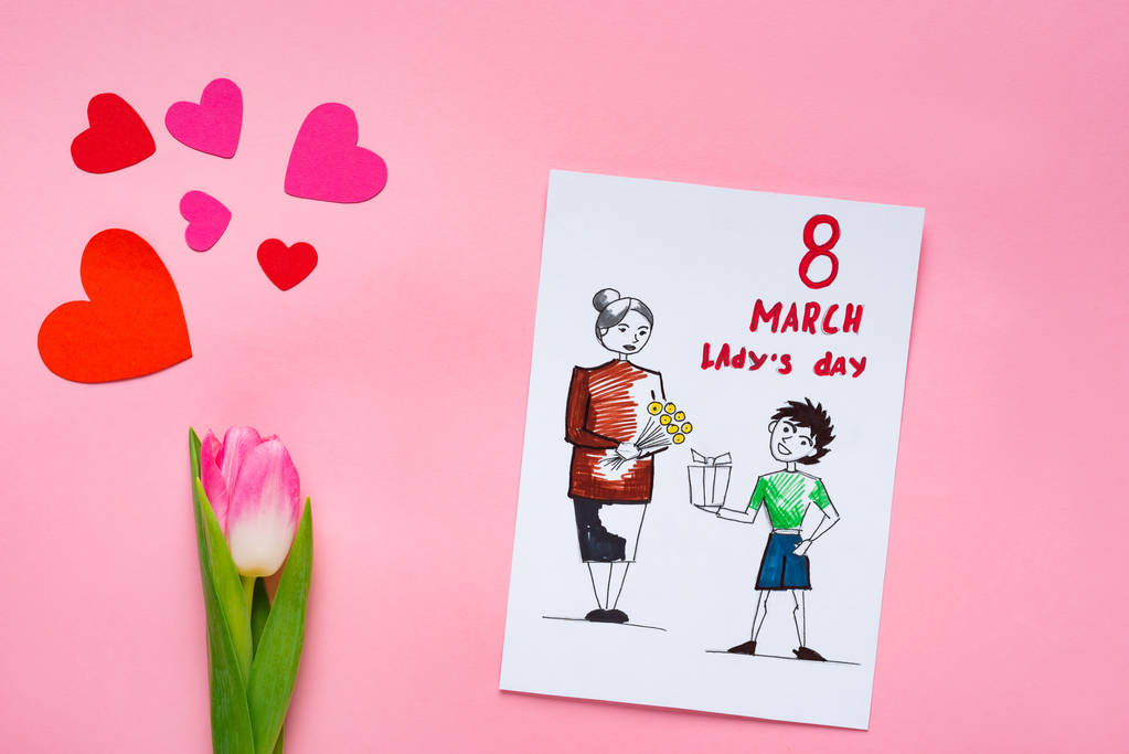 Top kilátás üdvözlő kártya rajz és 8 március ladys napi betű és tulipán papír szív rózsaszín felületen - Fotó, kép