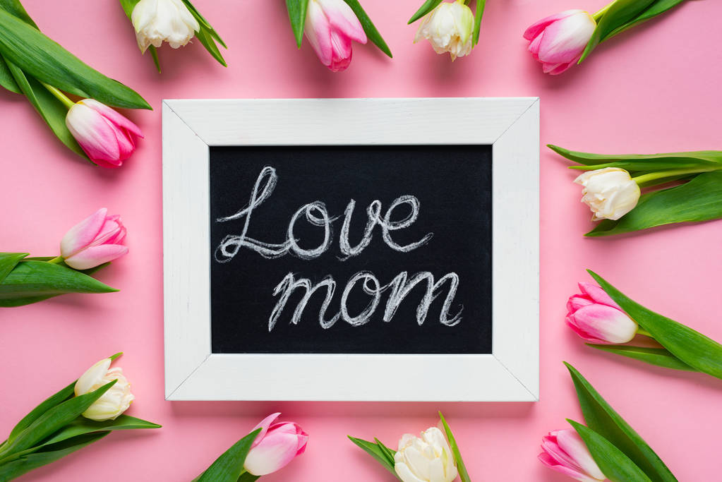 Top view of tulips around chalkboard with love mom lettering on pink background - Photo, Image